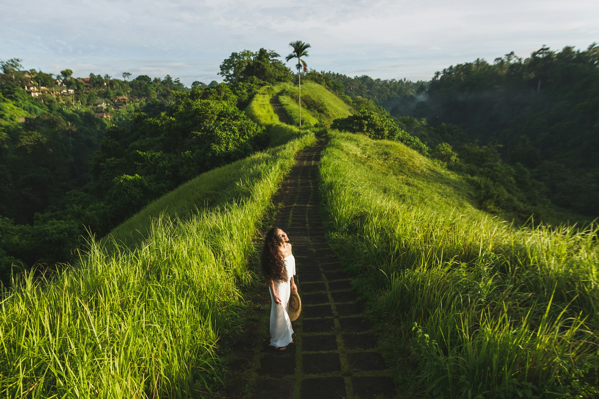 Young beautiful woman walking on Campuhan Ridge way of artists, in Bali, Ubud.